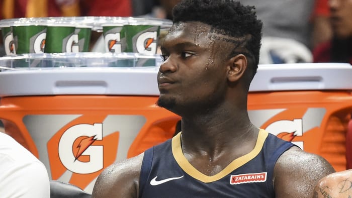 Zion Williamson sits on the Pelicans bench during preseason.